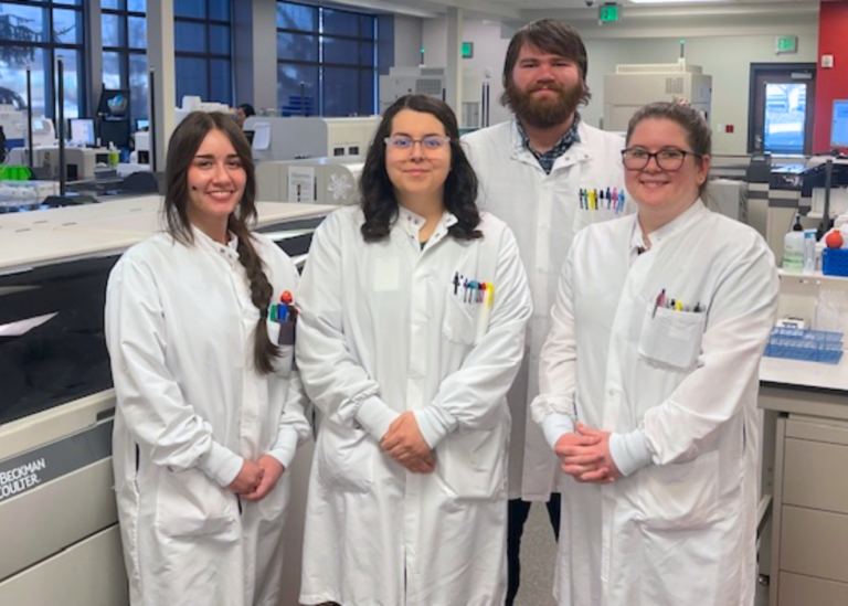 Interpath Lab Team in lab coats, standing in a group in the Pendleton Lab